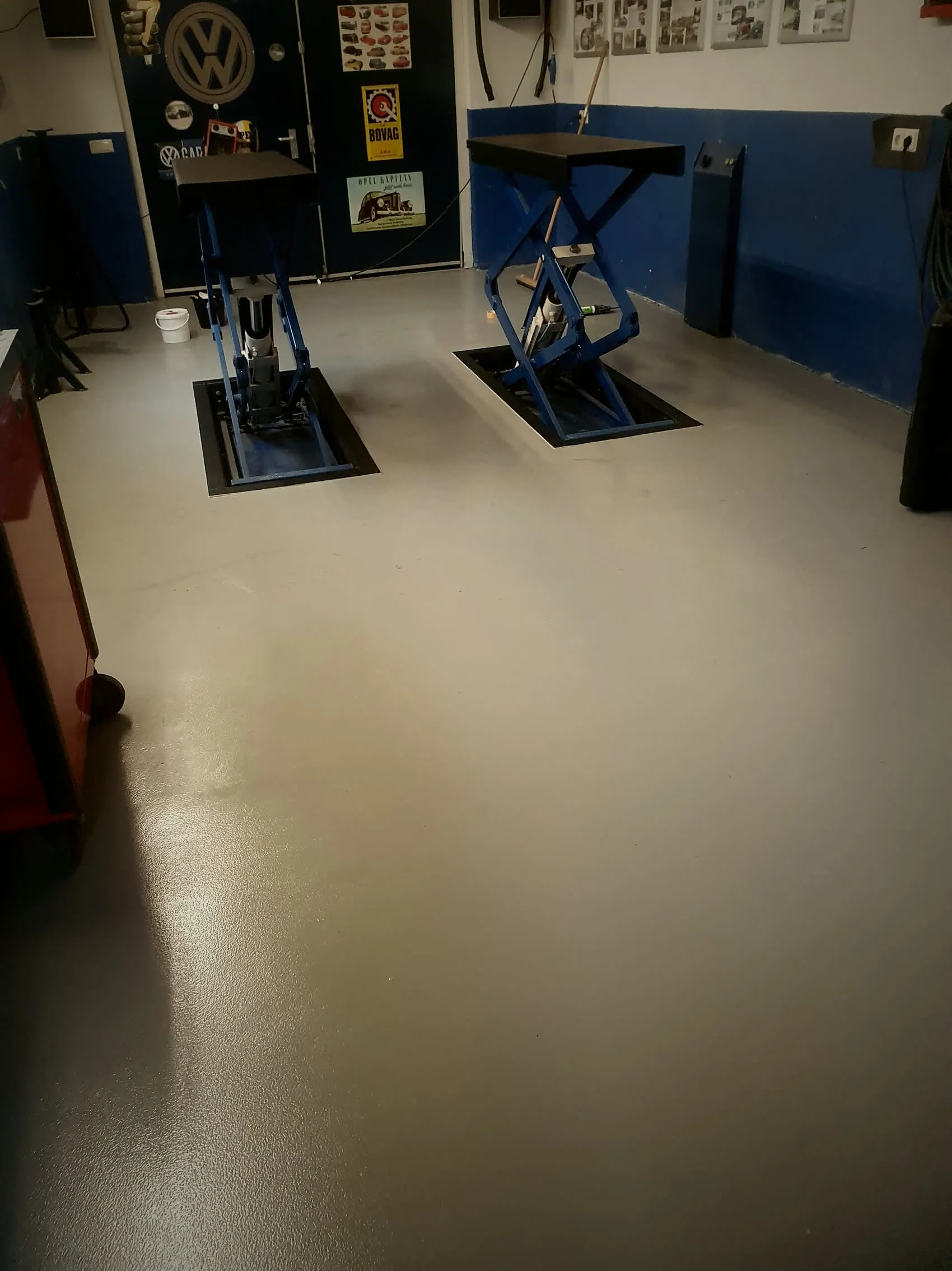 Werkplaats met lichte epoxyvloer, hefbruggen en gereedschapswanden