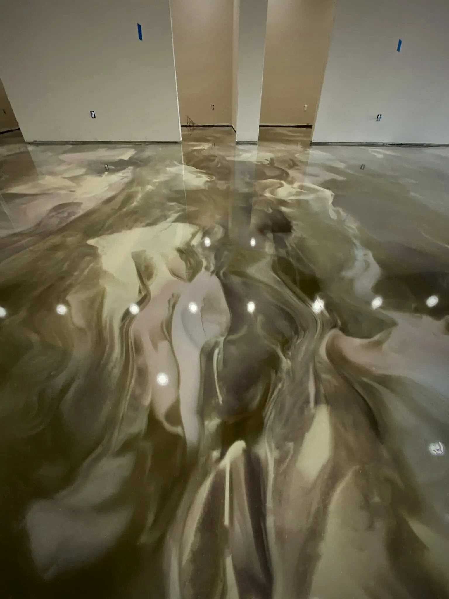 Metallic kunstharsvloer met parelmoeren wolking waarin de spots weerspiegelen